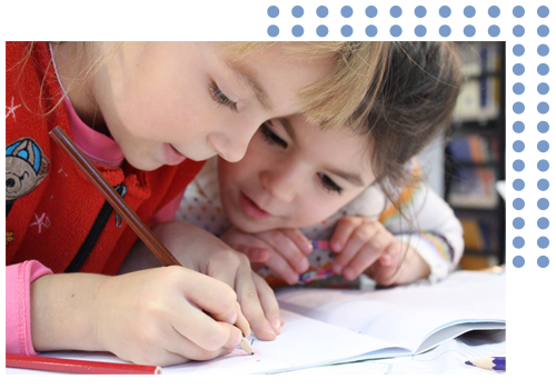 two children looking closely at a book